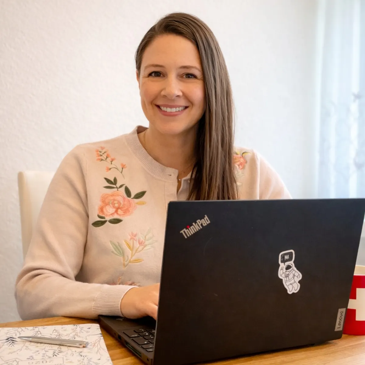 Jessica Gamper smiling at her laptop at a kitchen table